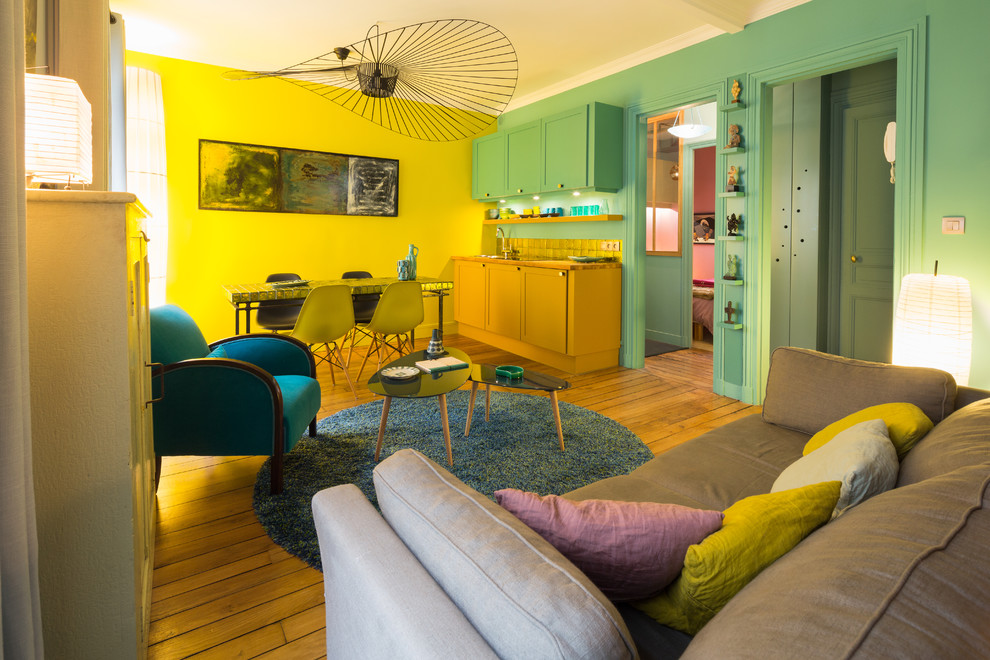 Idée de décoration pour un salon vintage de taille moyenne et ouvert avec un mur jaune, un sol en bois brun, aucune cheminée et aucun téléviseur.