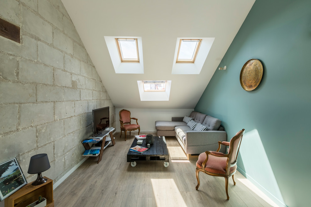 Foto de salón tipo loft contemporáneo de tamaño medio sin chimenea con paredes verdes, suelo de madera clara, televisor independiente, suelo beige y ladrillo