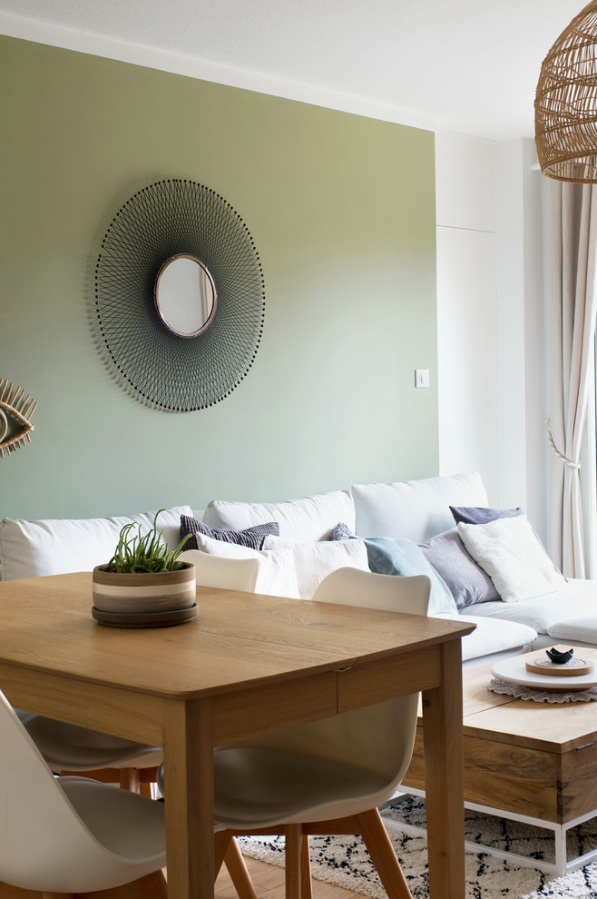 Ejemplo de salón abierto nórdico de tamaño medio sin chimenea con paredes verdes, suelo de madera clara, televisor independiente y suelo beige