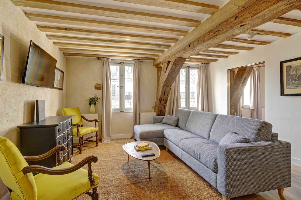 Idee per un soggiorno classico con pareti bianche, pavimento in legno massello medio, TV a parete e pavimento marrone