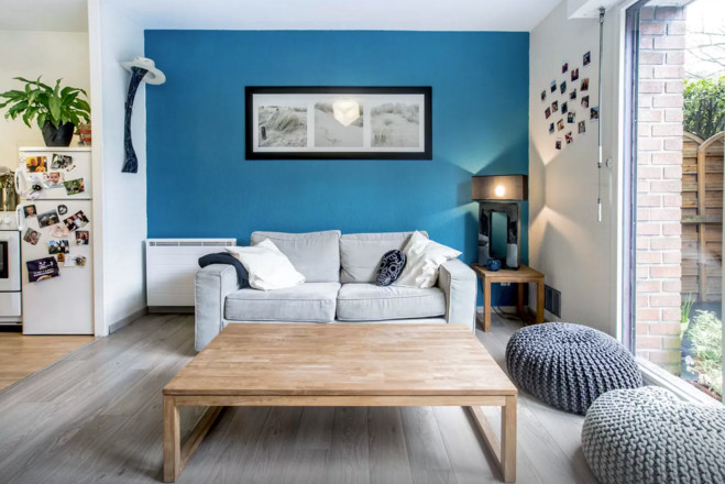 Inspiration för ett litet minimalistiskt separat vardagsrum, med blå väggar, ljust trägolv, en väggmonterad TV och grått golv