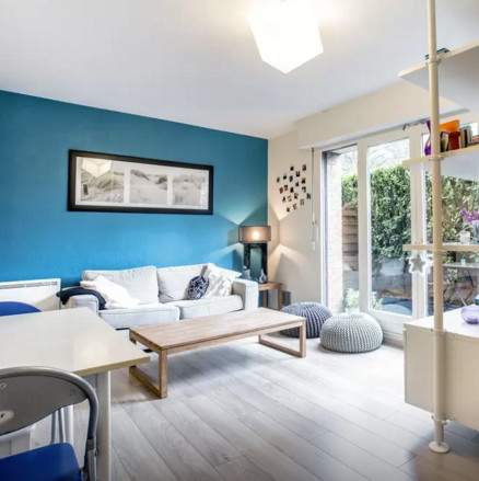 Cette image montre un petit salon nordique fermé avec un mur bleu, parquet clair, aucune cheminée, un téléviseur fixé au mur et un sol gris.