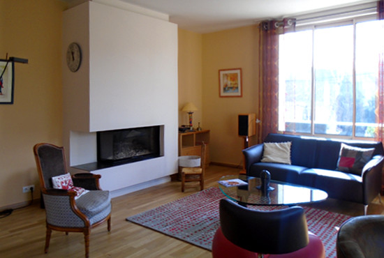 Exempel på ett mellanstort klassiskt allrum med öppen planlösning, med orange väggar, mörkt trägolv, en dubbelsidig öppen spis och en fristående TV
