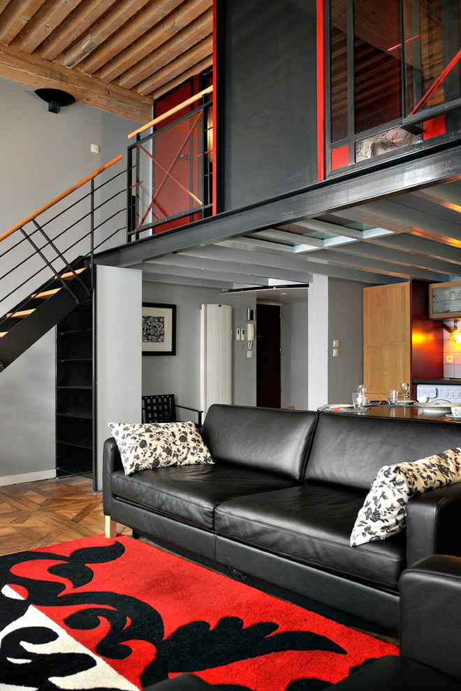 На фото: парадная гостиная комната среднего размера в стиле лофт с паркетным полом среднего тона и серыми стенами без камина, телевизора