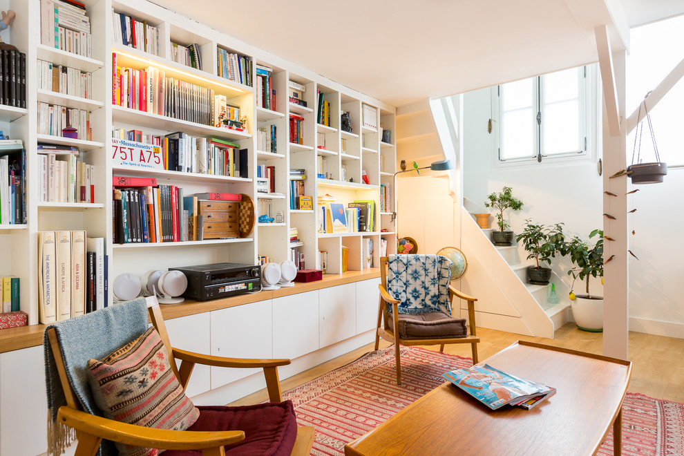 Offene, Mittelgroße, Fernseherlose Skandinavische Bibliothek ohne Kamin mit weißer Wandfarbe und braunem Holzboden in Paris