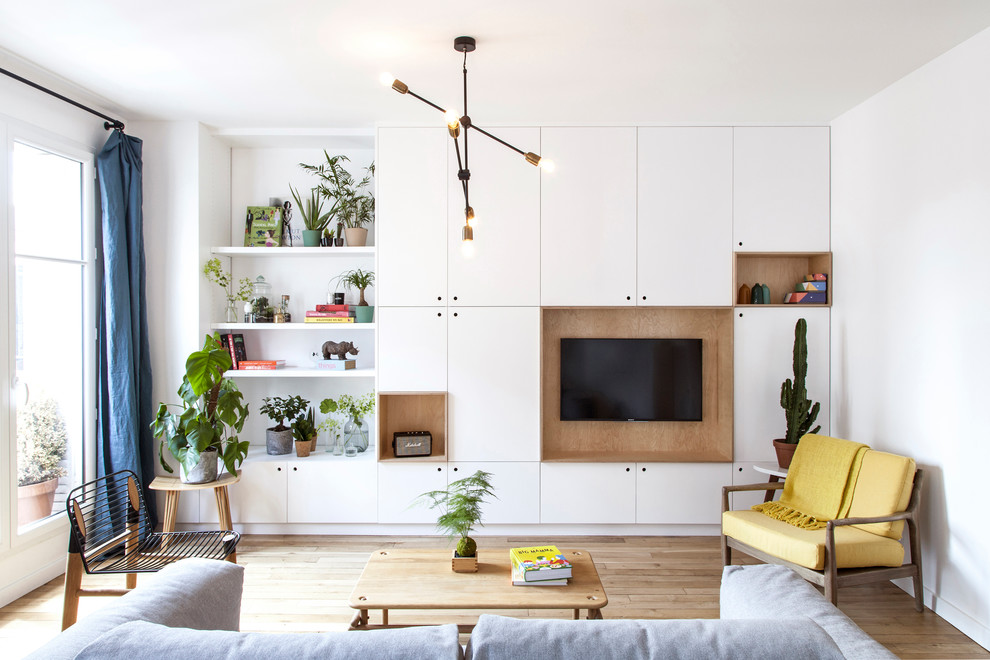 Modernes Wohnzimmer ohne Kamin mit weißer Wandfarbe, hellem Holzboden, TV-Wand und beigem Boden in Paris