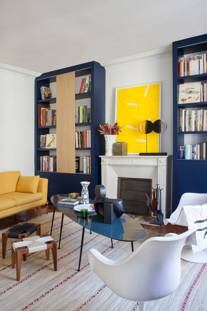Foto di un soggiorno minimal con libreria, pareti bianche e camino classico