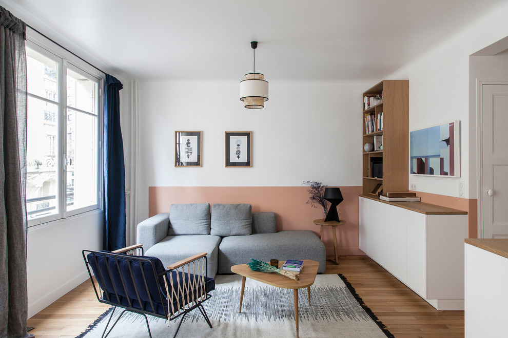 На фото: открытая гостиная комната в современном стиле с розовыми стенами, паркетным полом среднего тона, коричневым полом и синими шторами с