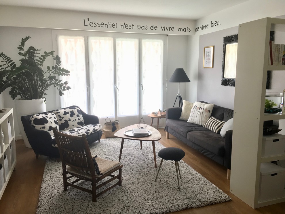 Immagine di un soggiorno bohémian di medie dimensioni e chiuso con pareti bianche, parquet chiaro, TV autoportante e pavimento beige