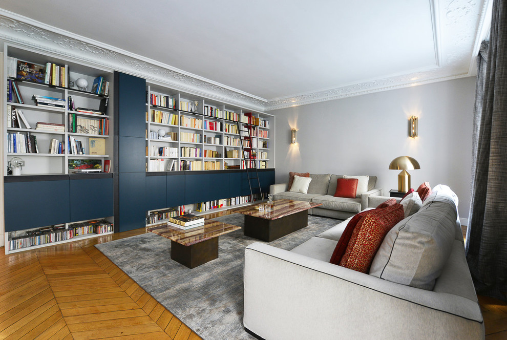 Repräsentatives, Abgetrenntes Modernes Wohnzimmer mit grauer Wandfarbe, hellem Holzboden, beigem Boden und verstecktem TV in Paris