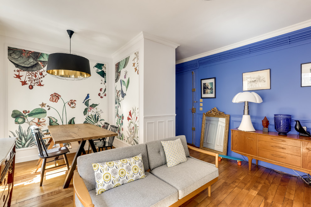 Offenes Stilmix Wohnzimmer mit bunten Wänden und braunem Holzboden in Paris