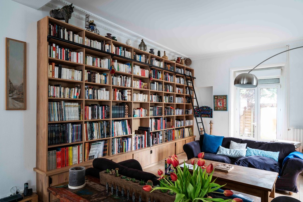 Exemple d'un grand salon tendance ouvert avec une bibliothèque ou un coin lecture, un mur blanc, parquet clair, aucune cheminée, aucun téléviseur et un sol beige.