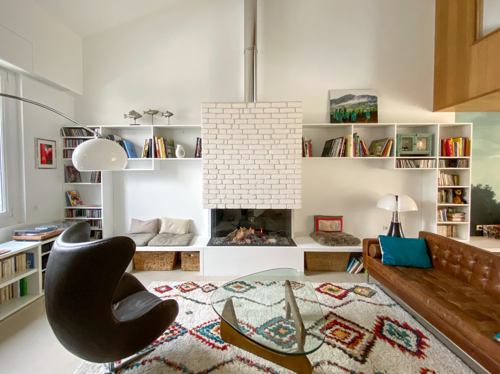 Idee per un soggiorno minimal aperto e di medie dimensioni con pareti bianche, camino classico, libreria, pavimento in cemento, nessuna TV e pavimento beige