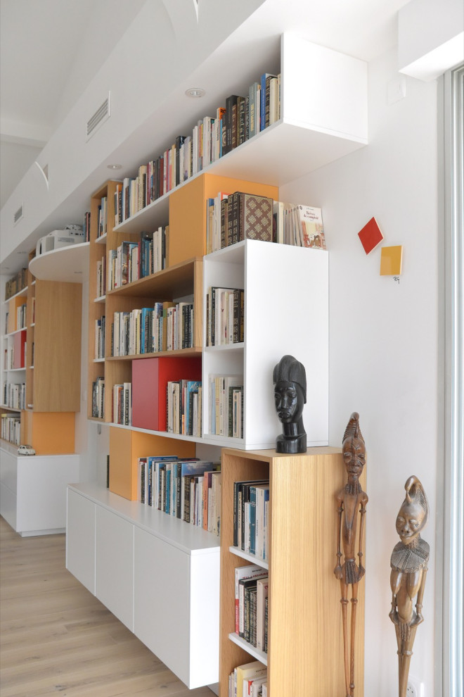 Inspiration för stora moderna allrum med öppen planlösning, med ett bibliotek, vita väggar, ljust trägolv, en öppen vedspis, en dold TV och beiget golv