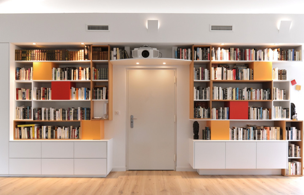 Exemple d'un grand salon tendance ouvert avec une bibliothèque ou un coin lecture, un mur blanc, parquet clair, un poêle à bois, un téléviseur fixé au mur et poutres apparentes.