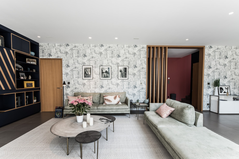 На фото: открытая гостиная комната в современном стиле с серыми стенами, серым полом и обоями на стенах с