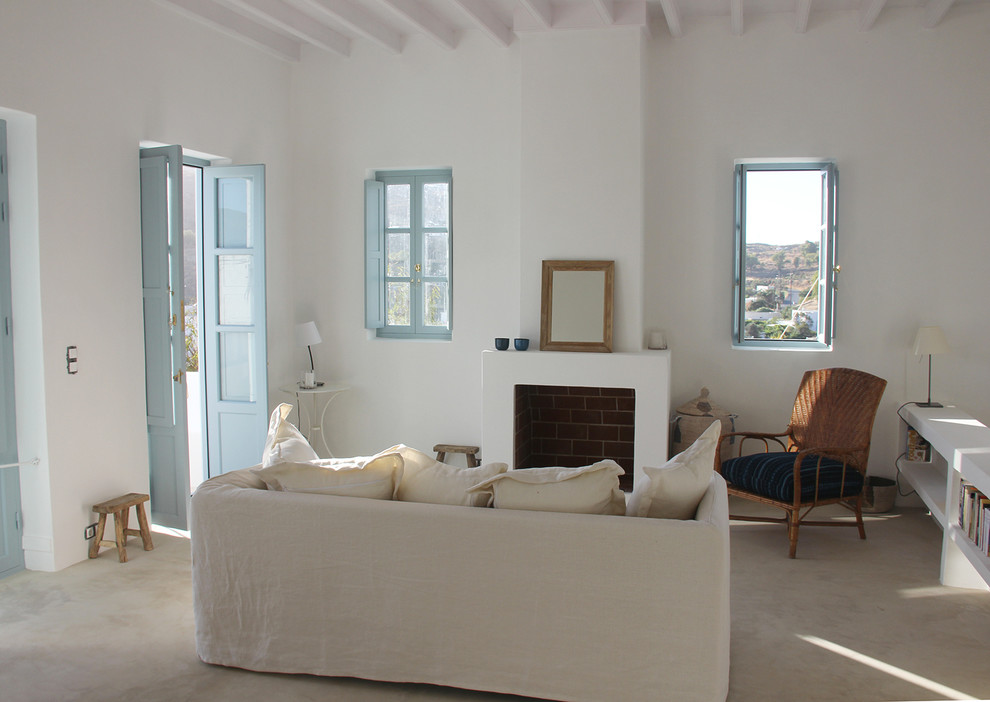 Idee per un soggiorno stile marino chiuso con pareti bianche, pavimento in cemento e camino classico