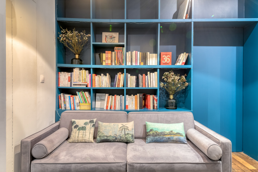 Пример оригинального дизайна: домашняя библиотека среднего размера в современном стиле с синими стенами, паркетным полом среднего тона, коричневым полом и отдельно стоящим рабочим столом без камина