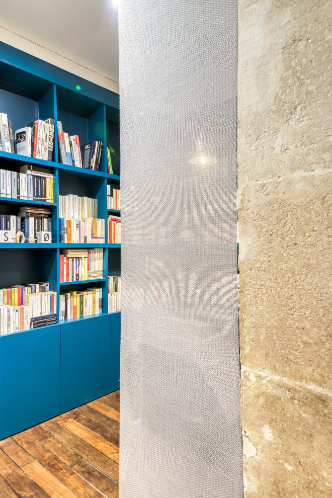 Réalisation d'un bureau design de taille moyenne avec une bibliothèque ou un coin lecture, un mur bleu, un sol en bois brun, aucune cheminée, un sol marron et un bureau indépendant.