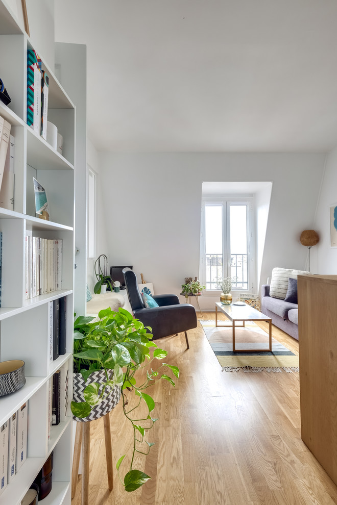 Imagen de salón abierto nórdico de tamaño medio con paredes blancas, suelo de madera clara, televisor independiente y suelo beige