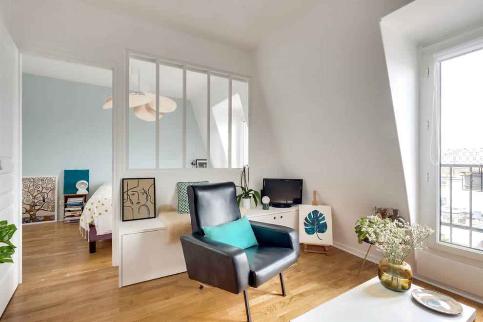Diseño de salón abierto nórdico de tamaño medio con paredes blancas, suelo de madera clara, televisor independiente y suelo beige