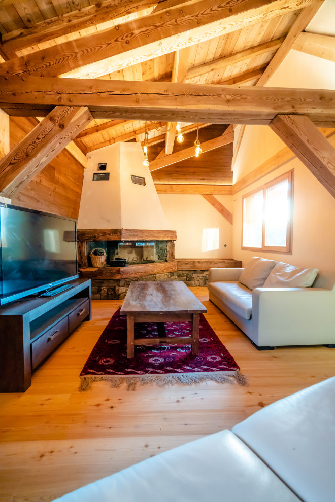 Idée de décoration pour un salon chalet en bois ouvert avec un sol en bois brun, une cheminée d'angle et un plafond en bois.