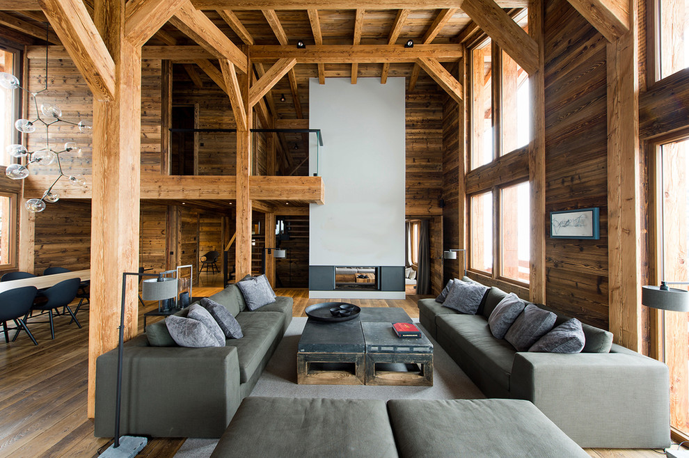 Modelo de salón para visitas abierto rústico extra grande sin televisor con paredes marrones, suelo de madera en tonos medios y chimenea de doble cara