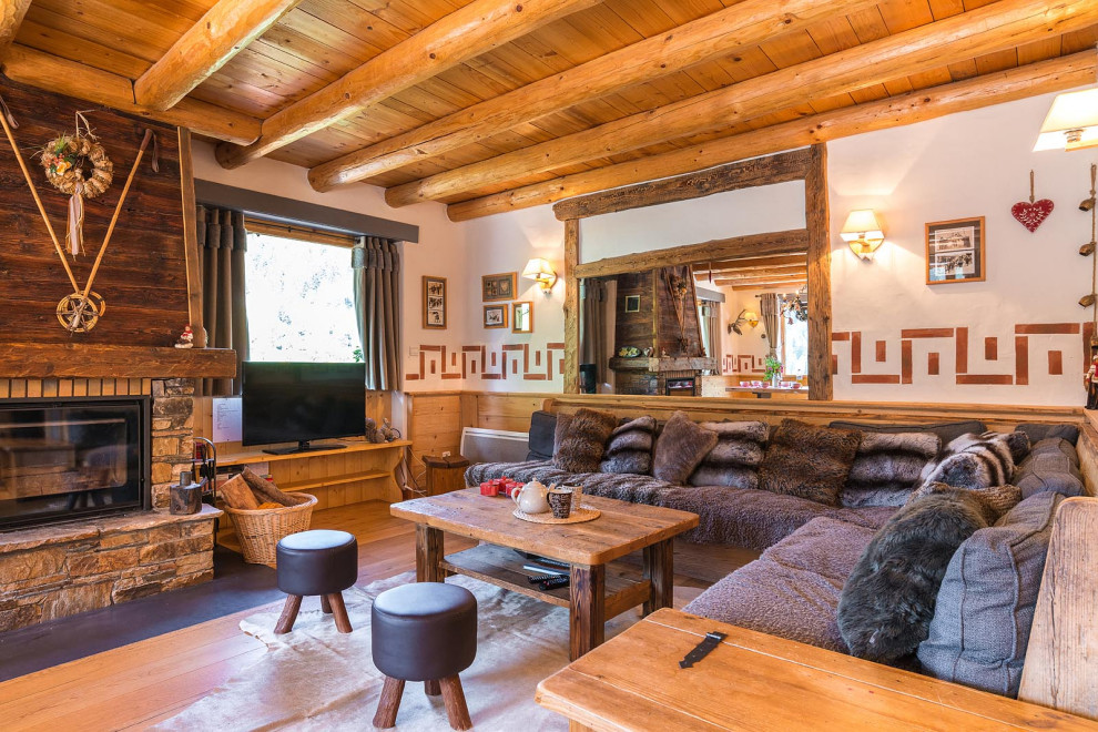 Inspiration for a large rustic formal open plan living room in Other with white walls, dark hardwood flooring, a standard fireplace, a timber clad chimney breast, a freestanding tv, brown floors, a wood ceiling and wood walls.