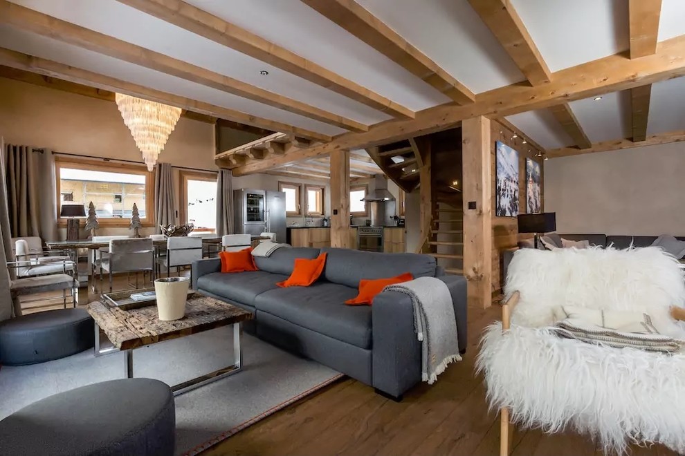 Imagen de salón abierto rural de tamaño medio sin televisor y chimenea con paredes beige y suelo de madera en tonos medios