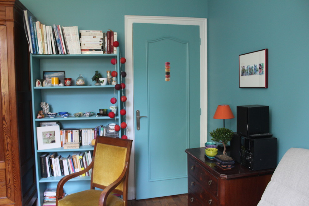 Inredning av ett eklektiskt mellanstort vardagsrum, med blå väggar och mörkt trägolv