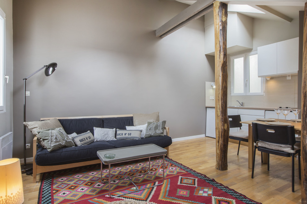 Esempio di un soggiorno minimal di medie dimensioni e aperto con pareti beige, pavimento in legno massello medio, nessun camino e nessuna TV