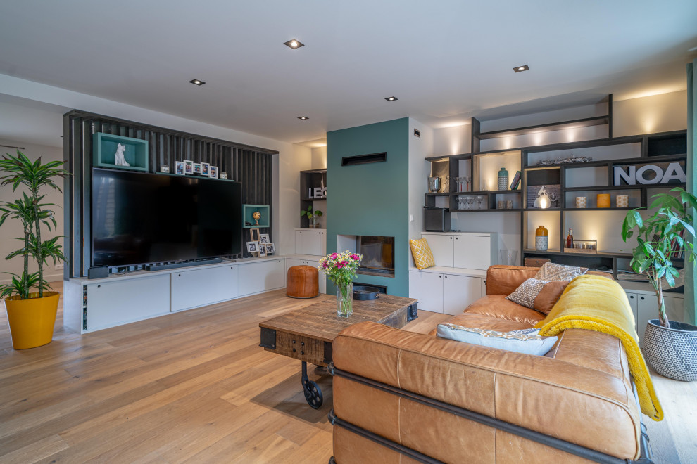 Aménagement d'un salon éclectique ouvert avec un mur blanc, un sol en bois brun, une cheminée standard, un téléviseur indépendant et un sol marron.