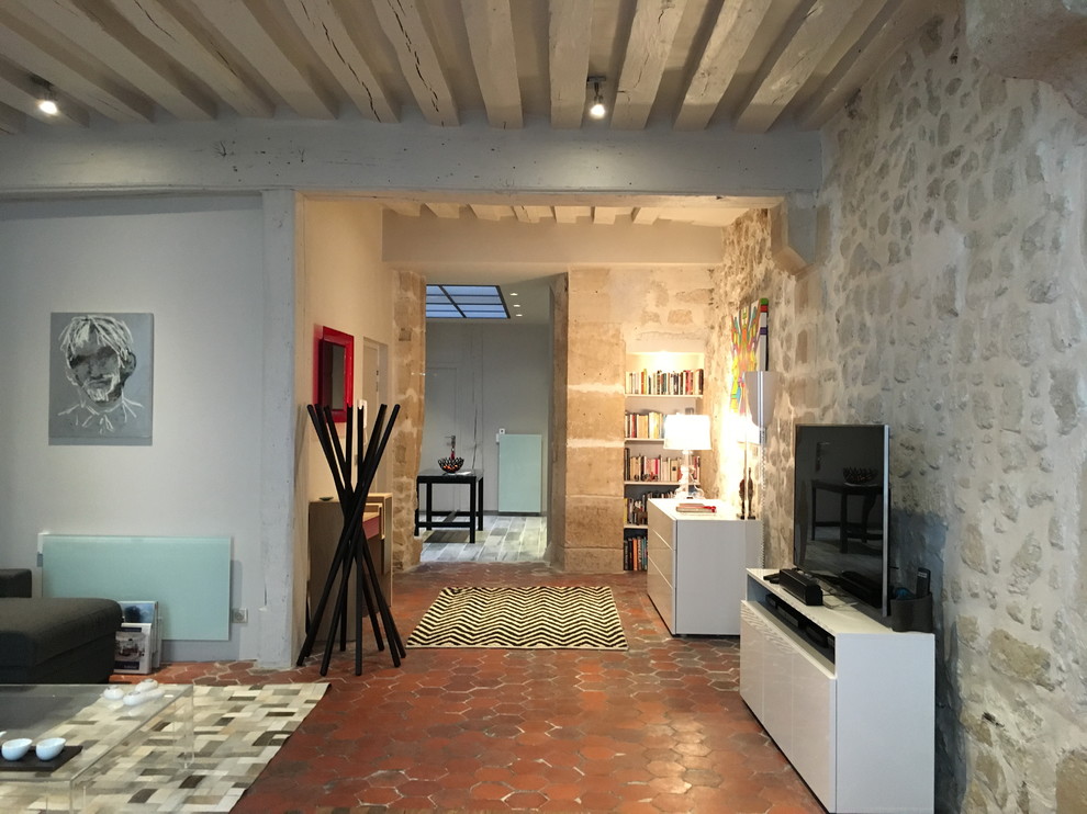 Immagine di un soggiorno minimal di medie dimensioni e aperto con pareti bianche, pavimento in terracotta e pavimento marrone