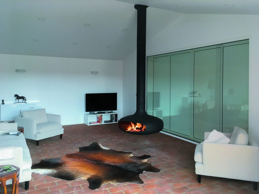 Cette image montre un salon minimaliste avec parquet foncé, cheminée suspendue et un manteau de cheminée en métal.