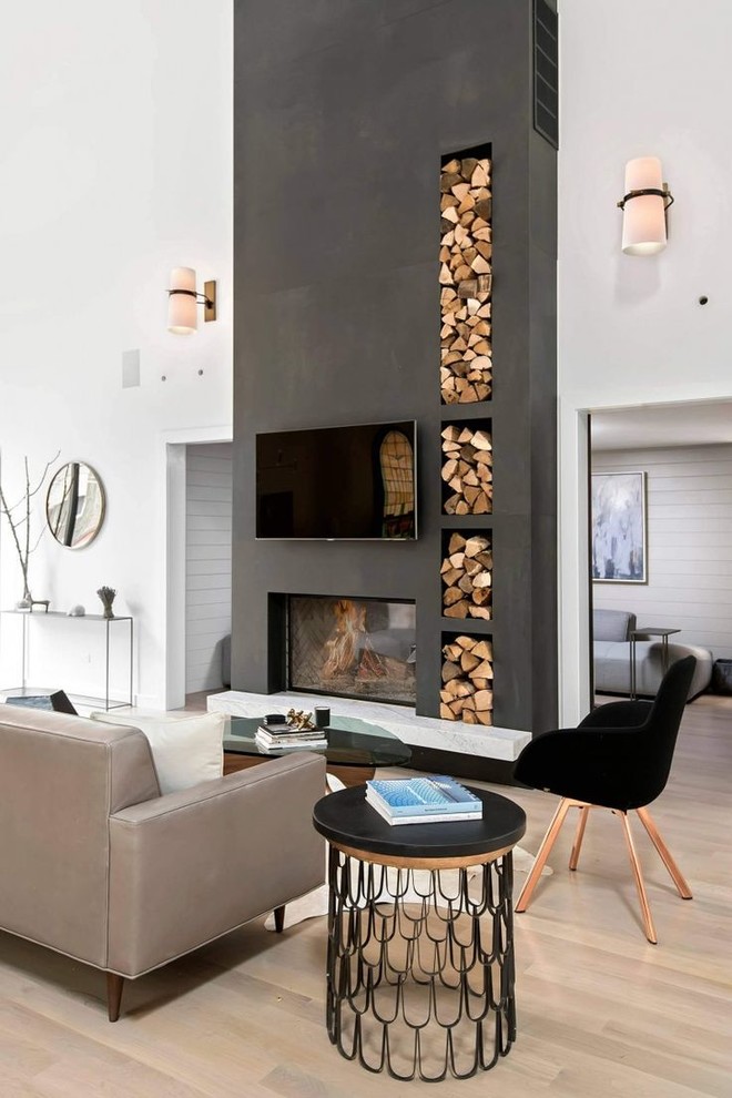 Diseño de salón contemporáneo con paredes blancas, suelo de madera clara, chimenea de doble cara, televisor colgado en la pared y suelo beige