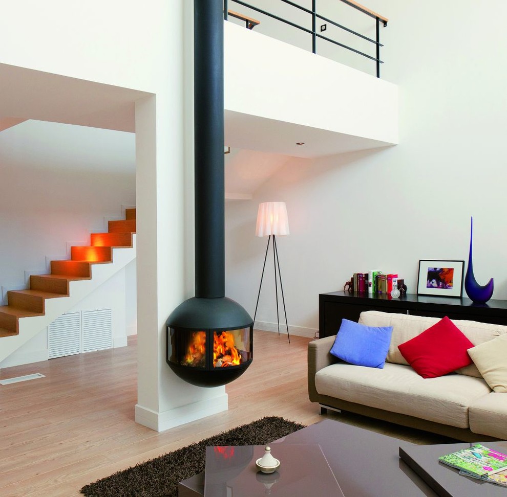 Idée de décoration pour un salon design avec cheminée suspendue et un manteau de cheminée en métal.