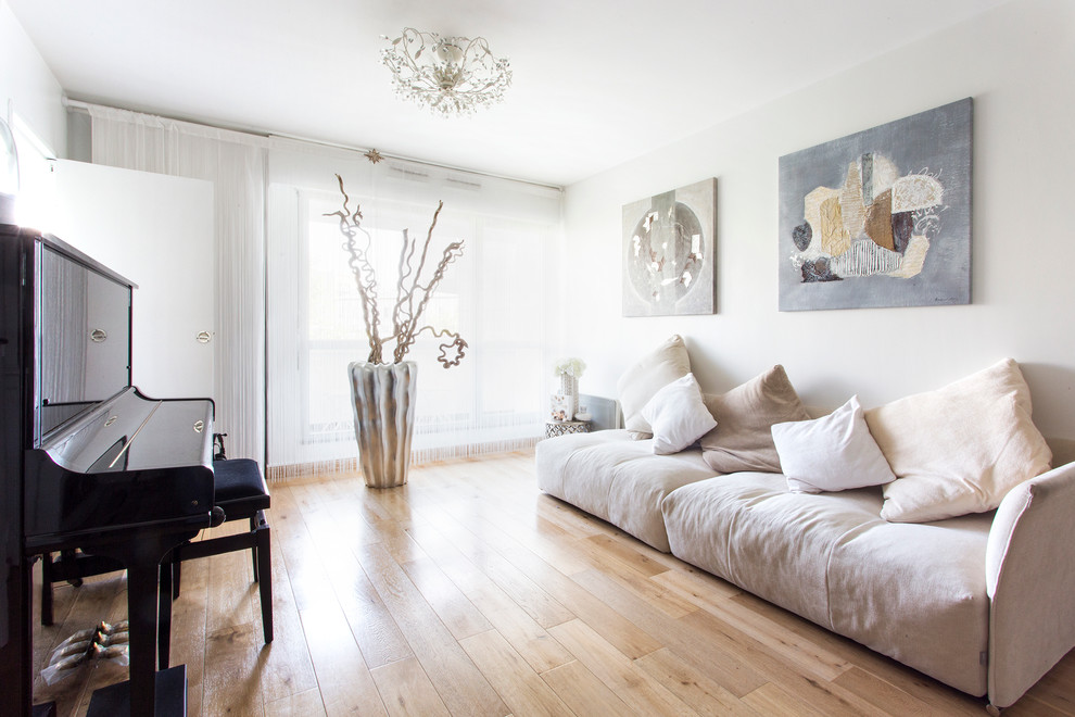 Modelo de salón con rincón musical clásico renovado con paredes blancas y suelo de madera clara