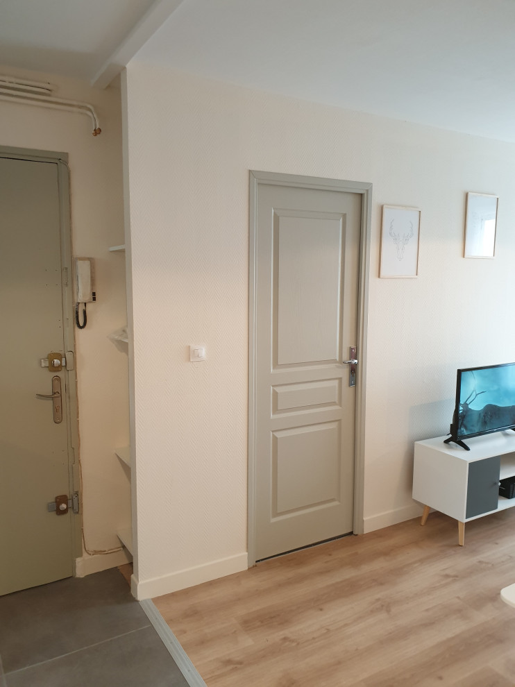 Aménagement d'un salon scandinave ouvert avec un mur beige, parquet clair, un téléviseur indépendant et un sol beige.