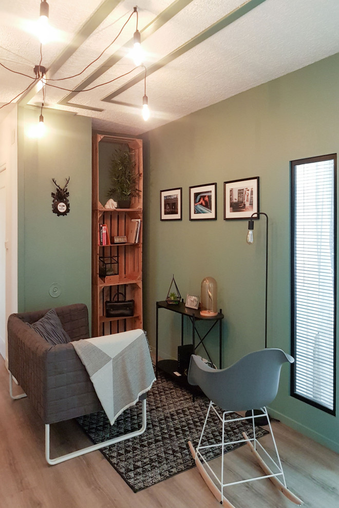 Imagen de biblioteca en casa cerrada urbana con paredes verdes, suelo beige y suelo de madera clara