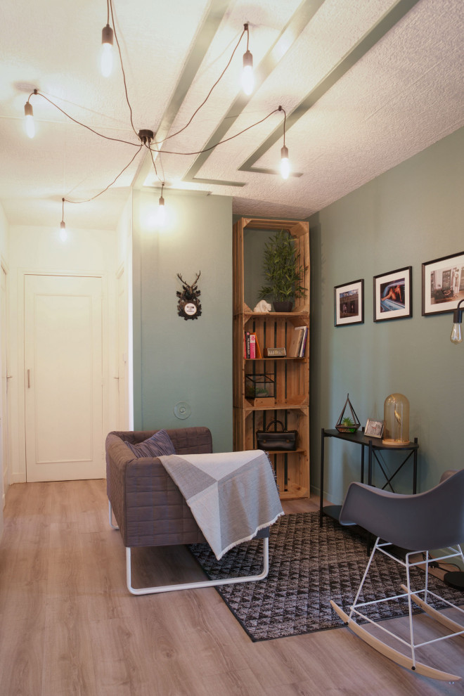 Esempio di un soggiorno industriale chiuso con libreria, pareti verdi, pavimento in vinile e pavimento beige