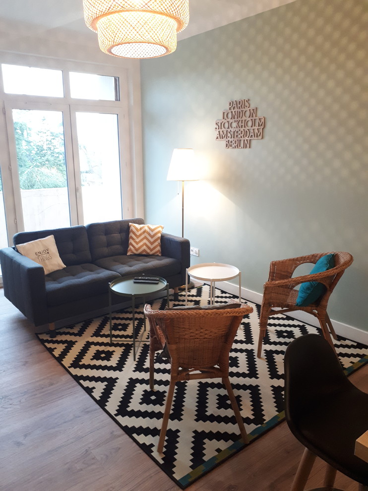 Großes, Offenes Nordisches Wohnzimmer ohne Kamin mit grüner Wandfarbe, Vinylboden, TV-Wand und braunem Boden in Sonstige