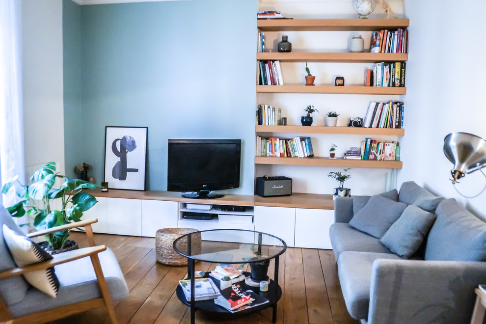 Idee per un soggiorno nordico di medie dimensioni con libreria e parquet chiaro