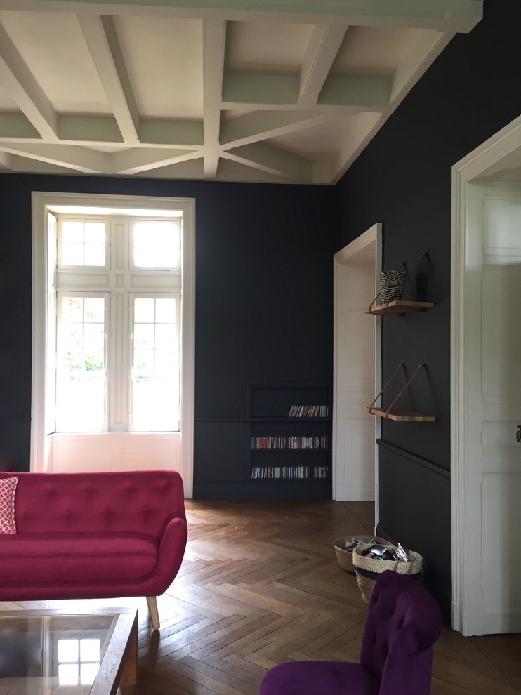 Großes, Fernseherloses, Abgetrenntes Stilmix Wohnzimmer mit schwarzer Wandfarbe, hellem Holzboden, Kamin, verputzter Kaminumrandung und beigem Boden in Angers