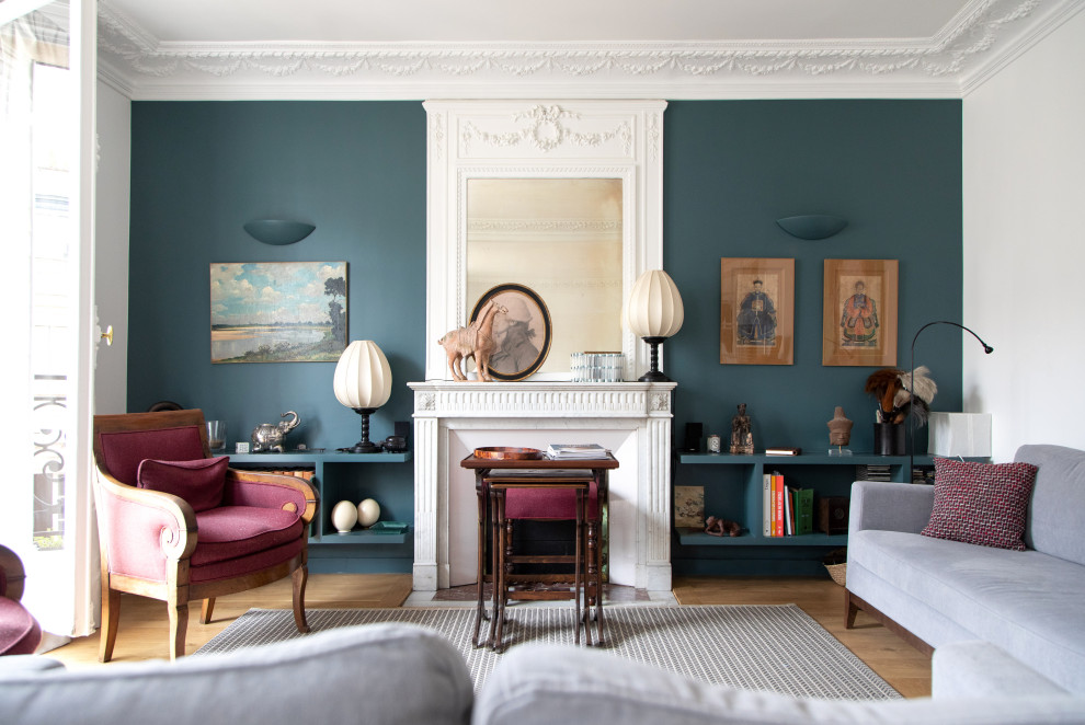 Пример оригинального дизайна: большая парадная гостиная комната в стиле фьюжн с синими стенами, стандартным камином и светлым паркетным полом без телевизора