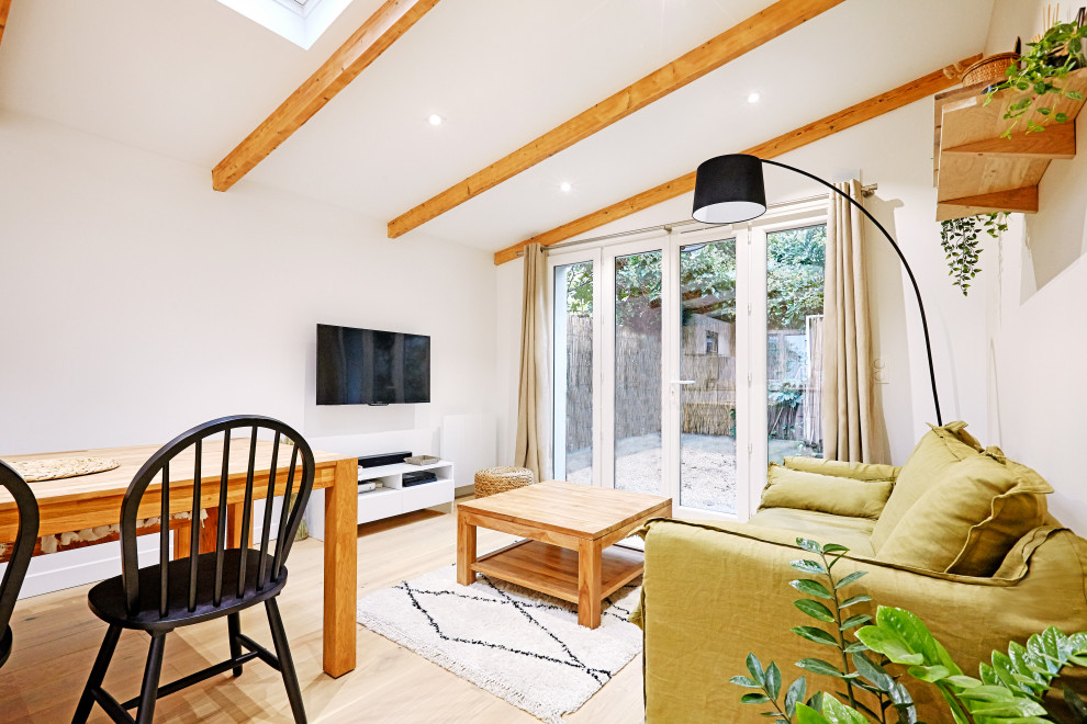 Medium sized scandi open plan living room in Paris with white walls, light hardwood flooring, no fireplace, a wall mounted tv, beige floors and exposed beams.