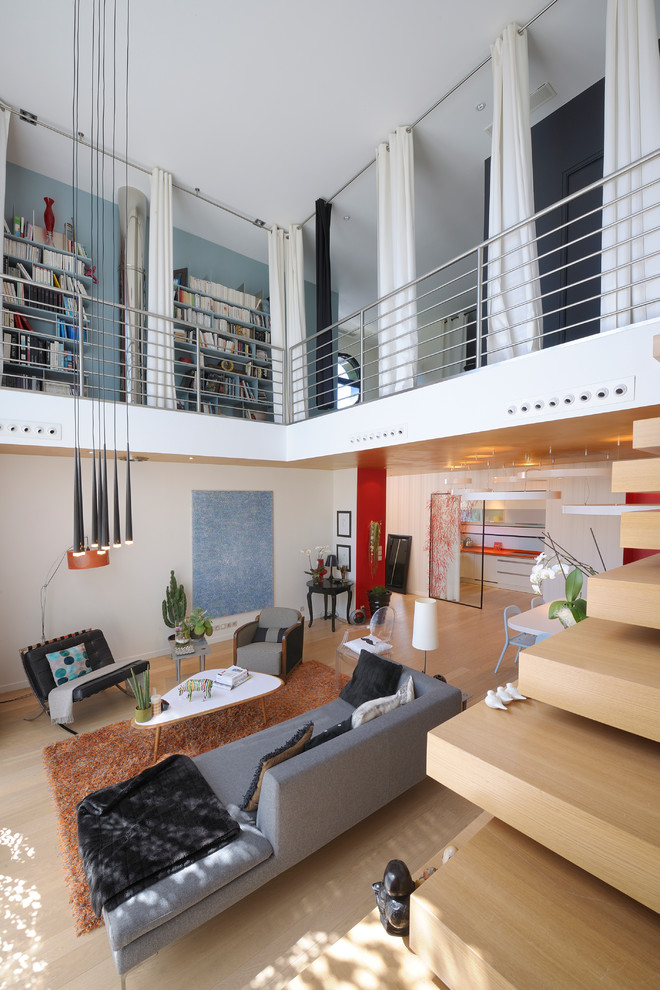 Foto de biblioteca en casa abierta contemporánea grande sin chimenea y televisor con paredes blancas y suelo de madera clara
