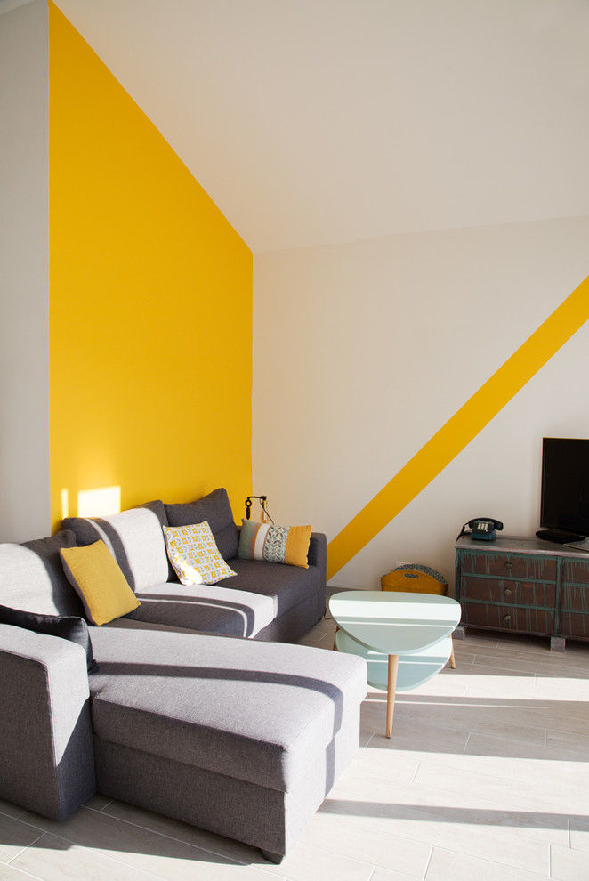 Inspiration för små moderna allrum med öppen planlösning, med grått golv, gula väggar och en fristående TV