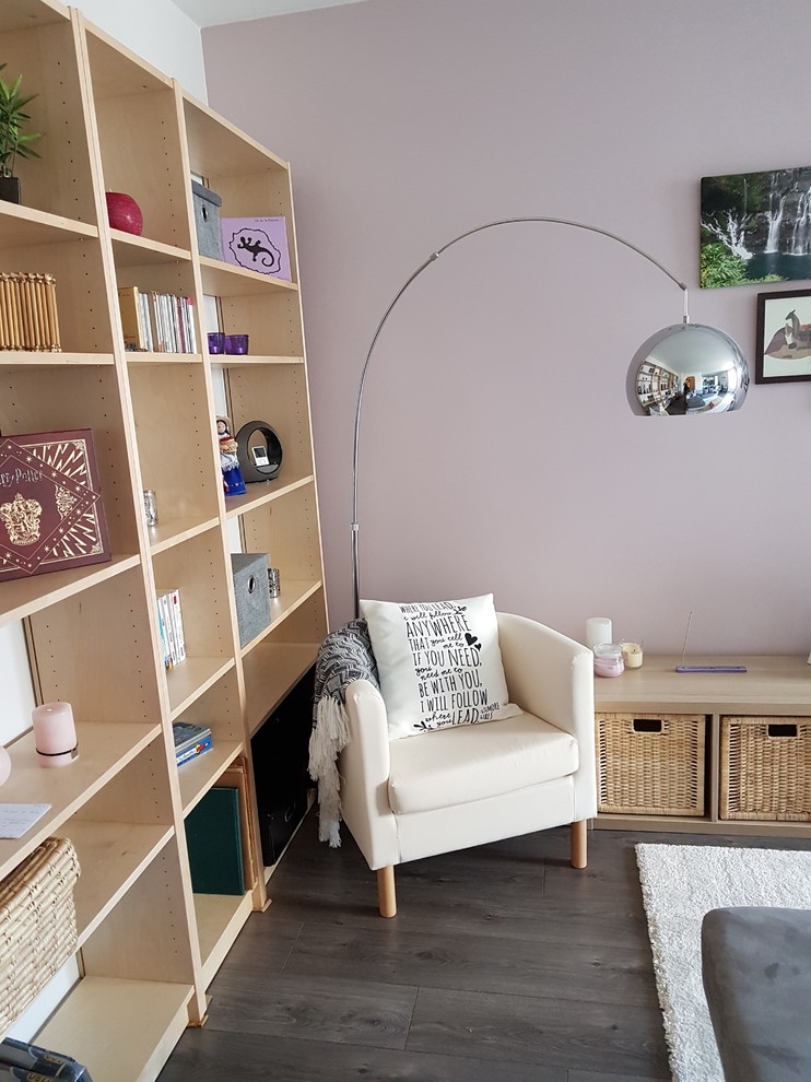 Modelo de salón abierto nórdico de tamaño medio con paredes rosas, suelo laminado, televisor independiente y suelo gris
