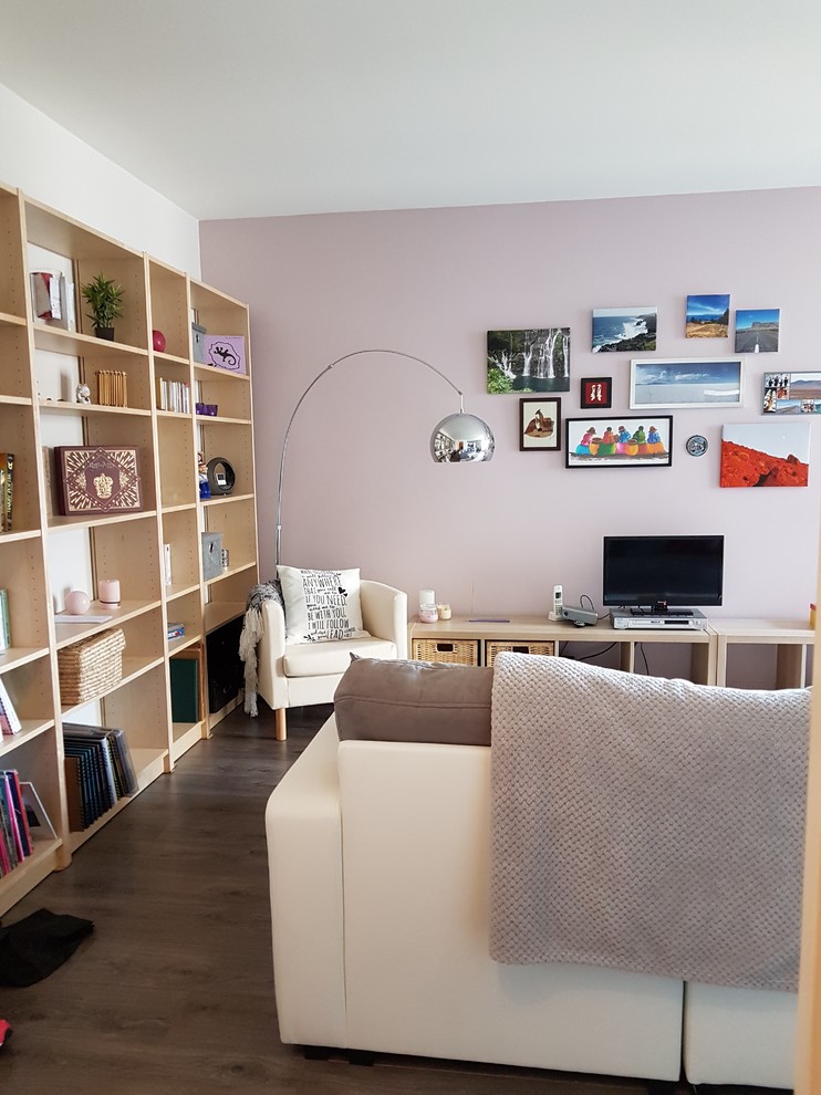 Idéer för mellanstora minimalistiska allrum med öppen planlösning, med ett bibliotek, rosa väggar, laminatgolv, en fristående TV och grått golv