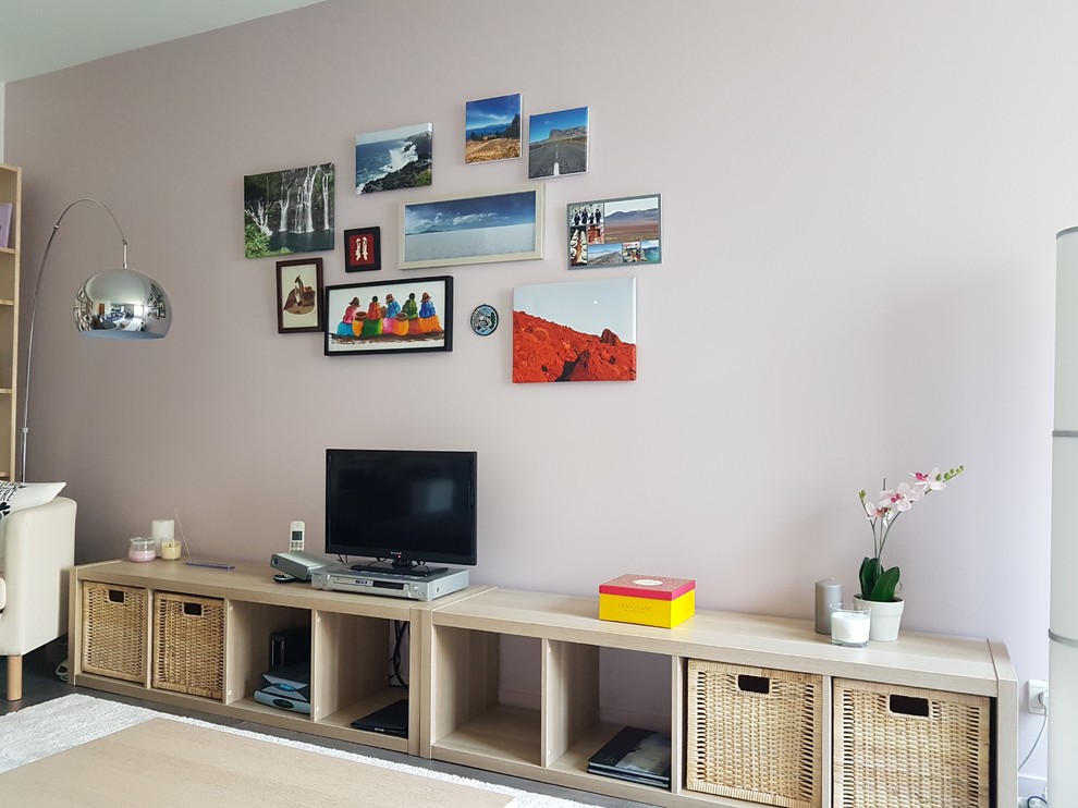 Diseño de salón abierto nórdico de tamaño medio con paredes rosas, suelo laminado, televisor independiente y suelo gris